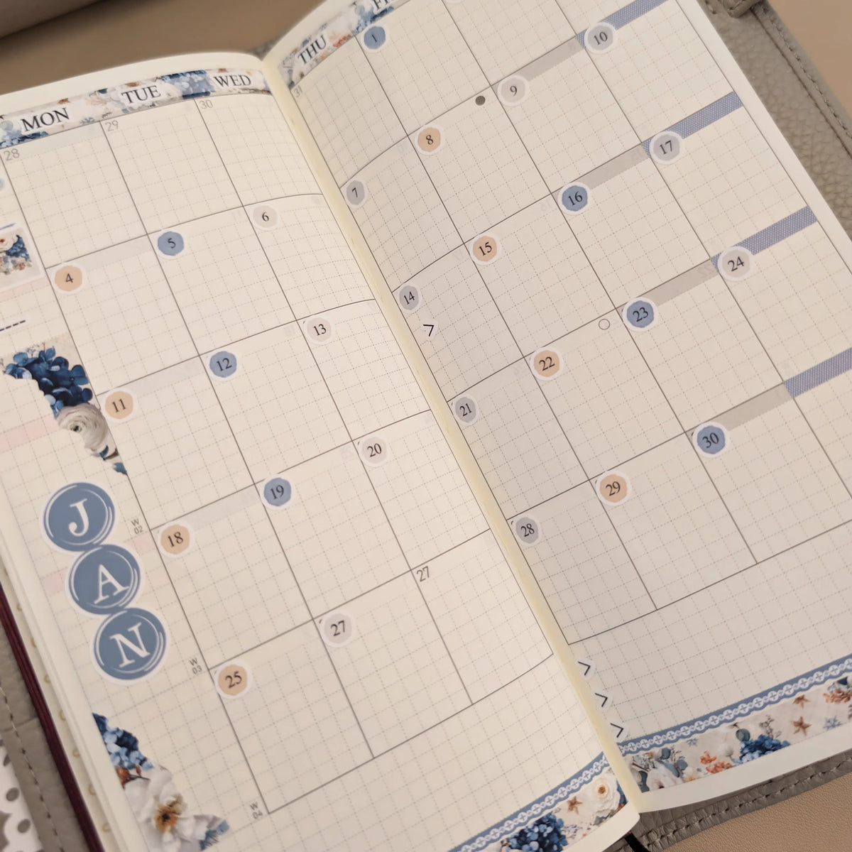 January date and floral stickers installed across a Hobonichi Weeks monthly calendar